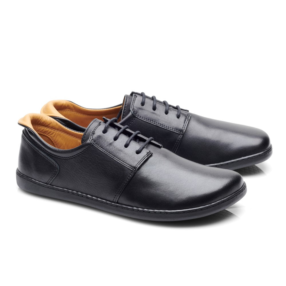 Die PIQUANT Nappa Black Schuhe von ZAQQ sind aus schwarzem Leder mit hellbraunem Innenfutter gefertigt, verfügen über Schnürsenkel und ein schlichtes Design. Sie werden nebeneinander auf einem weißen Hintergrund präsentiert.