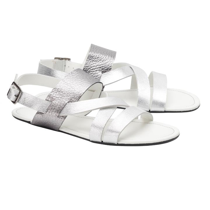 Die PERLAQ Silver von ZAQQ sind ein stilvolles Paar Barfuß-Riemchensandalen für Damen mit hochwertigen metallisch-silbernen Nappalederriemen mit verstellbaren Schnallen. Sie sind mit einer hochflexiblen Sohle und einem offenen Zehenbereich gestaltet, bei dem sich die Riemen elegant über den Fußrücken kreuzen.