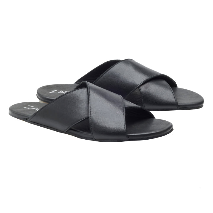 Ein Paar schwarze MANQA-Sandalen von ZAQQ aus feinem Nappaleder mit überkreuzten Riemen und flacher Sohle, elegant vor einem weißen Hintergrund präsentiert.