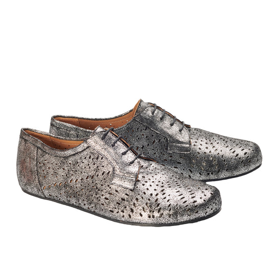 Die REMAQE Silver-Schuhe von ZAQQ sind ein klassischer Derby-Schnitt mit metallisch-silbernem Schnürdesign, das ein strukturiertes Muster und kleine Perforationen an den Seiten aufweist. Sie sind fachmännisch aus hochwertigem Nappaleder gefertigt und ihre glatte Silhouette ist aus einem Dreiviertelwinkel wunderschön zu sehen.