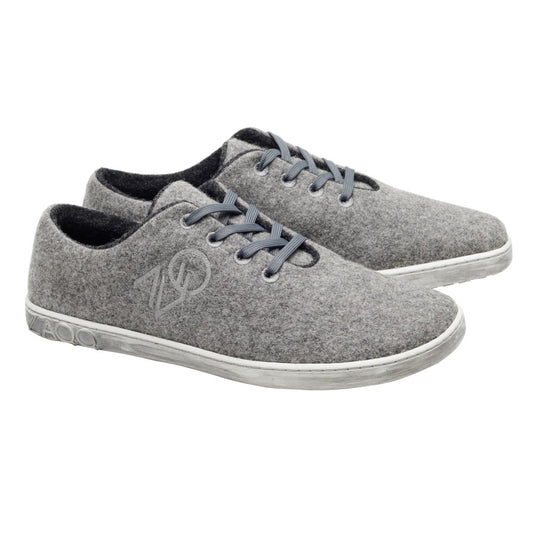 Die LIQE Grey von ZAQQ sind graue Schnürsneaker aus Merinowolle mit weißer Sohle und passenden grauen Schnürsenkeln. Diese Barfußschuhe präsentieren ein minimalistisches Design mit einem dezenten Logo an der Seite und sind temperaturregulierend für ultimativen Komfort.