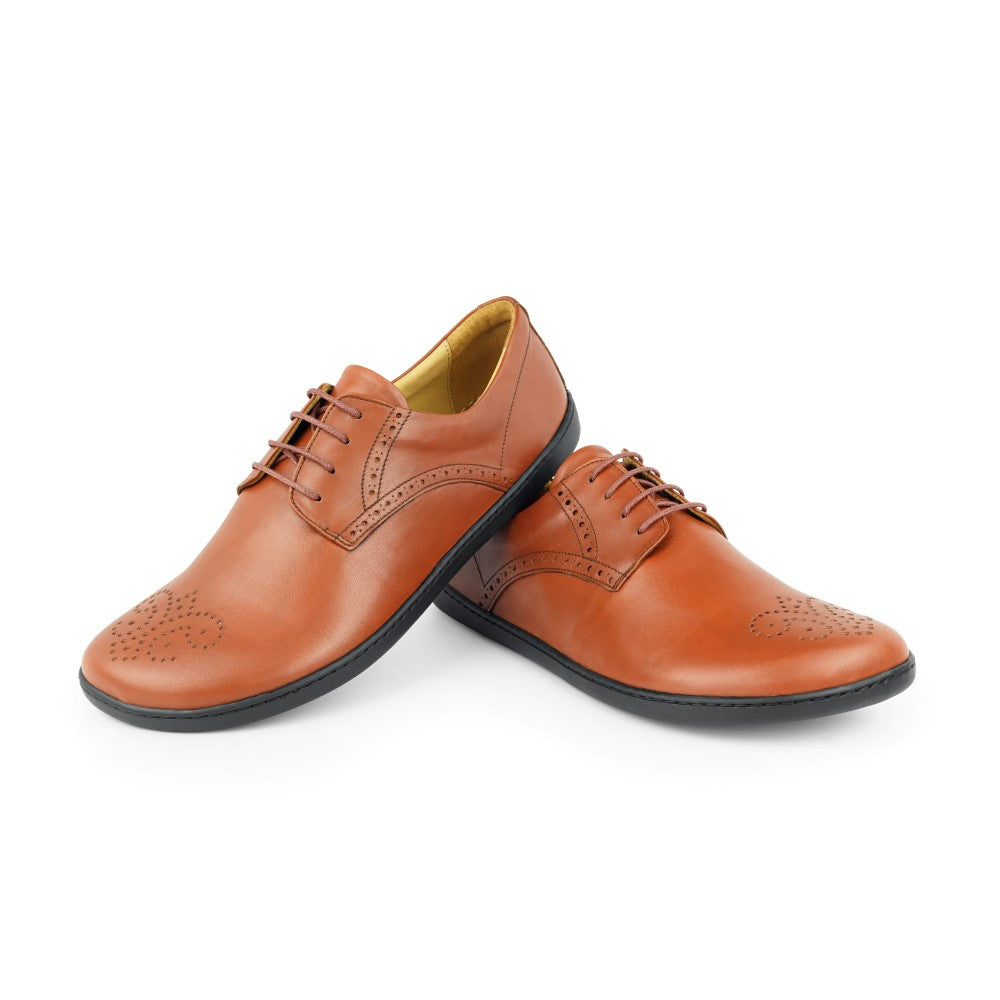 Der PEAQ Brogue Cognac von ZAQQ ist ein Paar eleganter Abendschuh mit exquisiter Brogue-Verzierung auf braunem Nappaleder, ergänzt durch schwarze Sohlen und hellbraunes Innenfutter, ideal für ein Business-Casual-Umfeld.