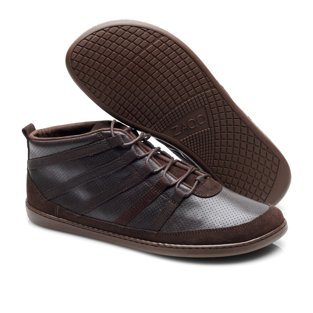 Die ZAQQ SPARQ Mid Dark Brown High-Top-Sneakers bieten eine perfekte Kombination aus Stil und Funktionalität und zeichnen sich durch strukturierte Sohlen und perforierte Details aus. Kreativ präsentiert: Ein Sneaker liegt flach, während der andere aufrecht steht, wodurch das komplizierte Design und das Sohlenmuster wunderschön zur Geltung kommen.