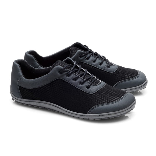 Abgebildet sind die SQIP Black Grey Sneaker von ZAQQ, die ein schwarzes veganer Design mit dunkelgrauen Akzenten und strukturiertem Stoff aufweisen. Die Schuhe haben Schnürungen vorne, graue Sohlen und bieten hohen Tragekomfort, leicht überlappend angeordnet auf weißem Hintergrund.