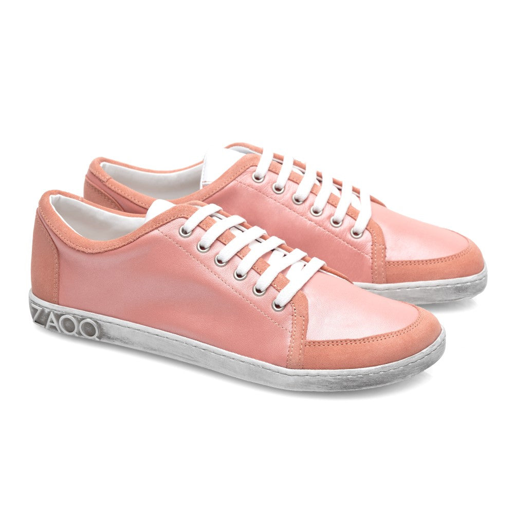 Die TIQQ Rosa Sneaker von ZAQQ sind aus hochwertigem rosa Nappaleder gefertigt, ergänzt durch weiße Schnürsenkel und Sohlen. Diese Schuhe zeichnen sich durch ein schlichtes, lässiges Design aus, wobei der Markenname ZAQQ elegant auf der Rückseite der Sohle angebracht ist. Sie werden vor einem strahlend weißen Hintergrund präsentiert.